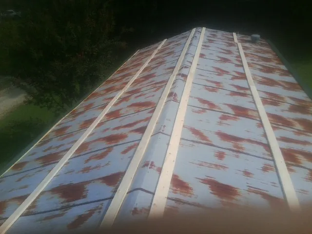 Rusted metal roof panels with new wood purlins before replacement — Storm Damage Roof Repair in Welton by Roofing Brothers