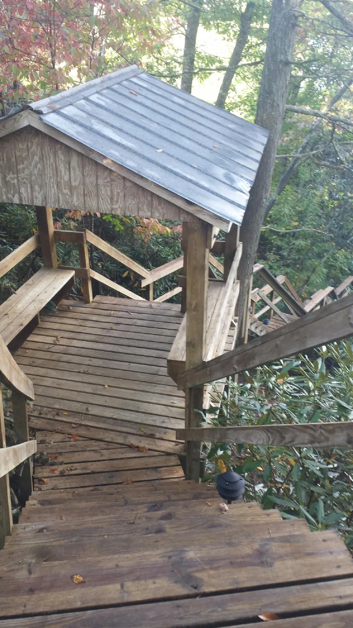 Metal roofed shelter over wooden steps on a wooded walkway — Skylight Repair & Installation work by our crew in Welton