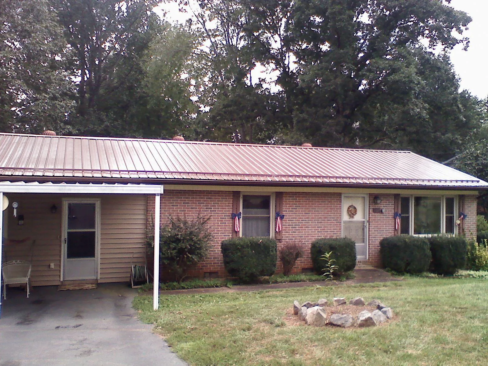 Bronze metal roof and carport on a brick ranch home — Roof Repair work by our crew in Welton